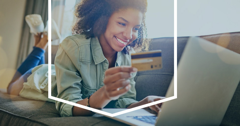 Woman Holding a Debit Card at Computer