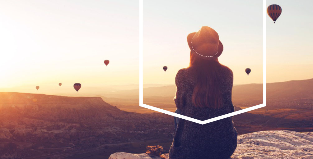 Woman Watches Rising Hot Air Balloons