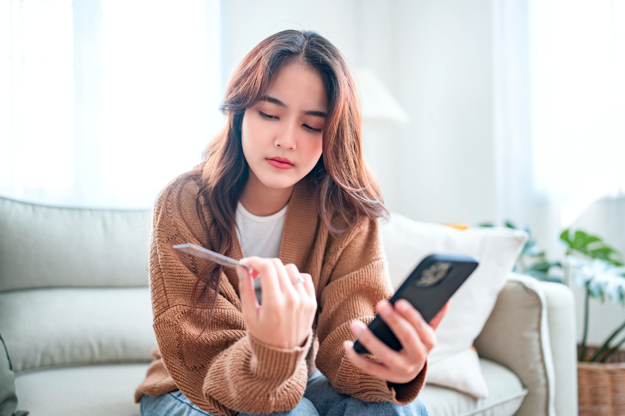 Woman looking at gift card disapprovingly