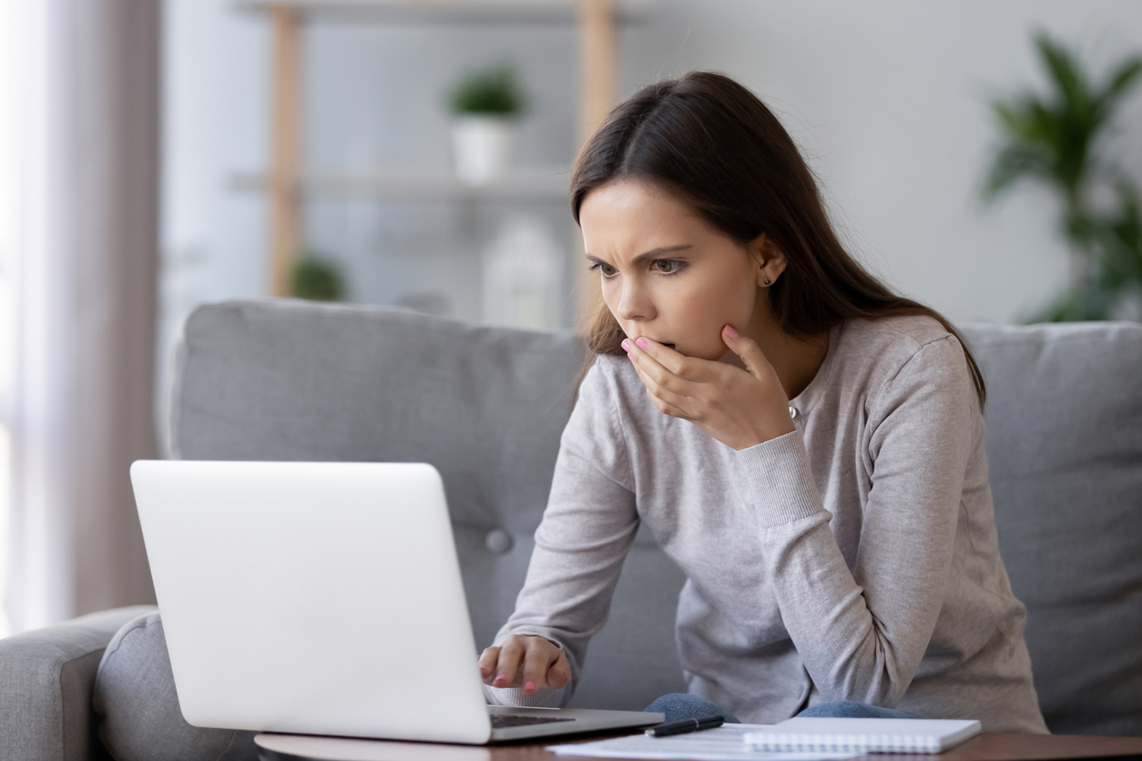 Woman looking at computer in shock