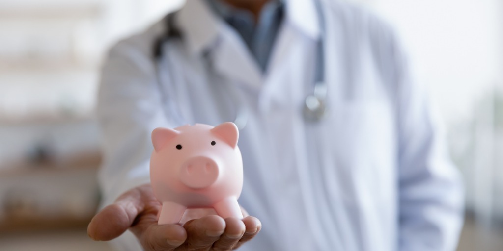 Doctor holding out a piggy bank