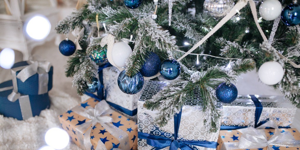 Christmas Gifts wrapped in silver and blue paper, backg