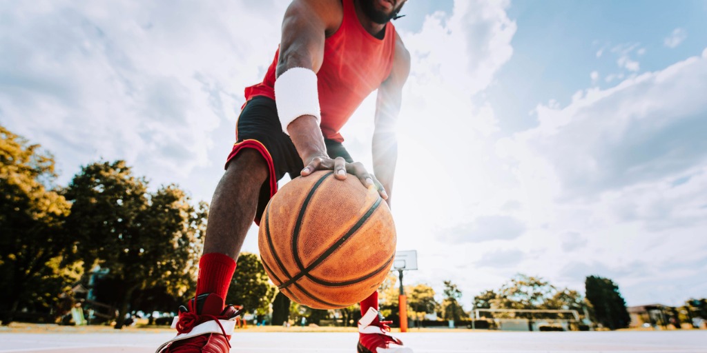 Basketball street player dribbling with ball on the cou