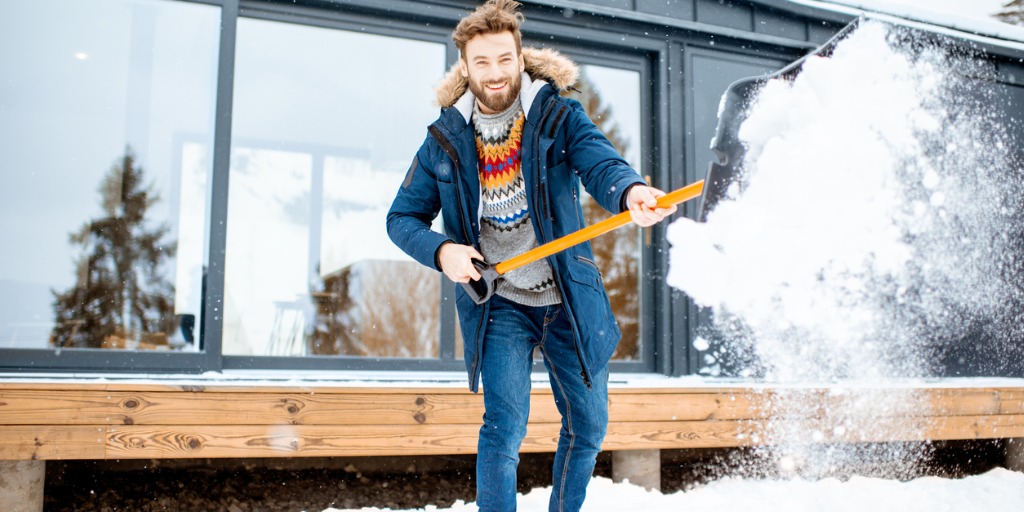 man cleaning snow near the house