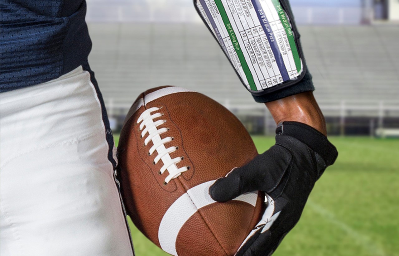 Football player wearing a wrist coach holding football