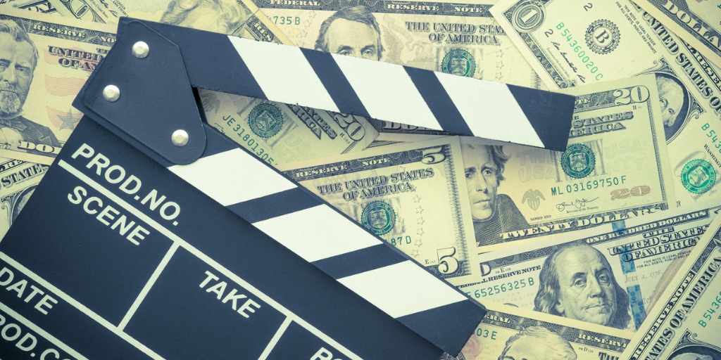 Cinema clapperboard on US dollars banknote bill backgro