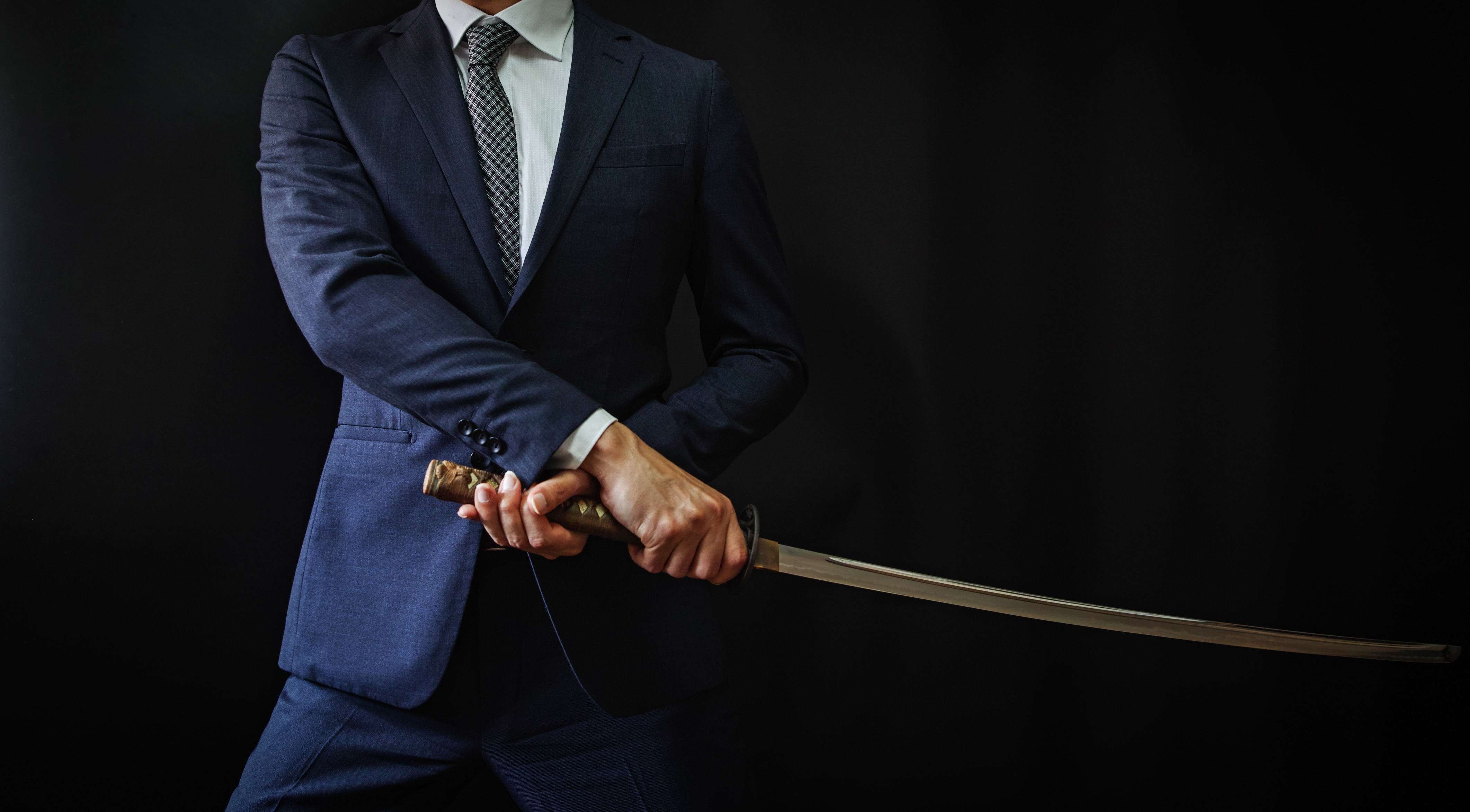 Businessman carrying a long Japanese katana sword