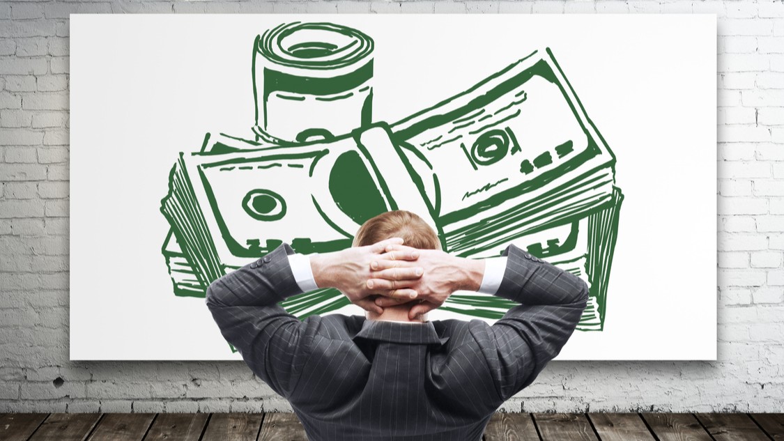 Relaxing young businessman looking at creative dollar b