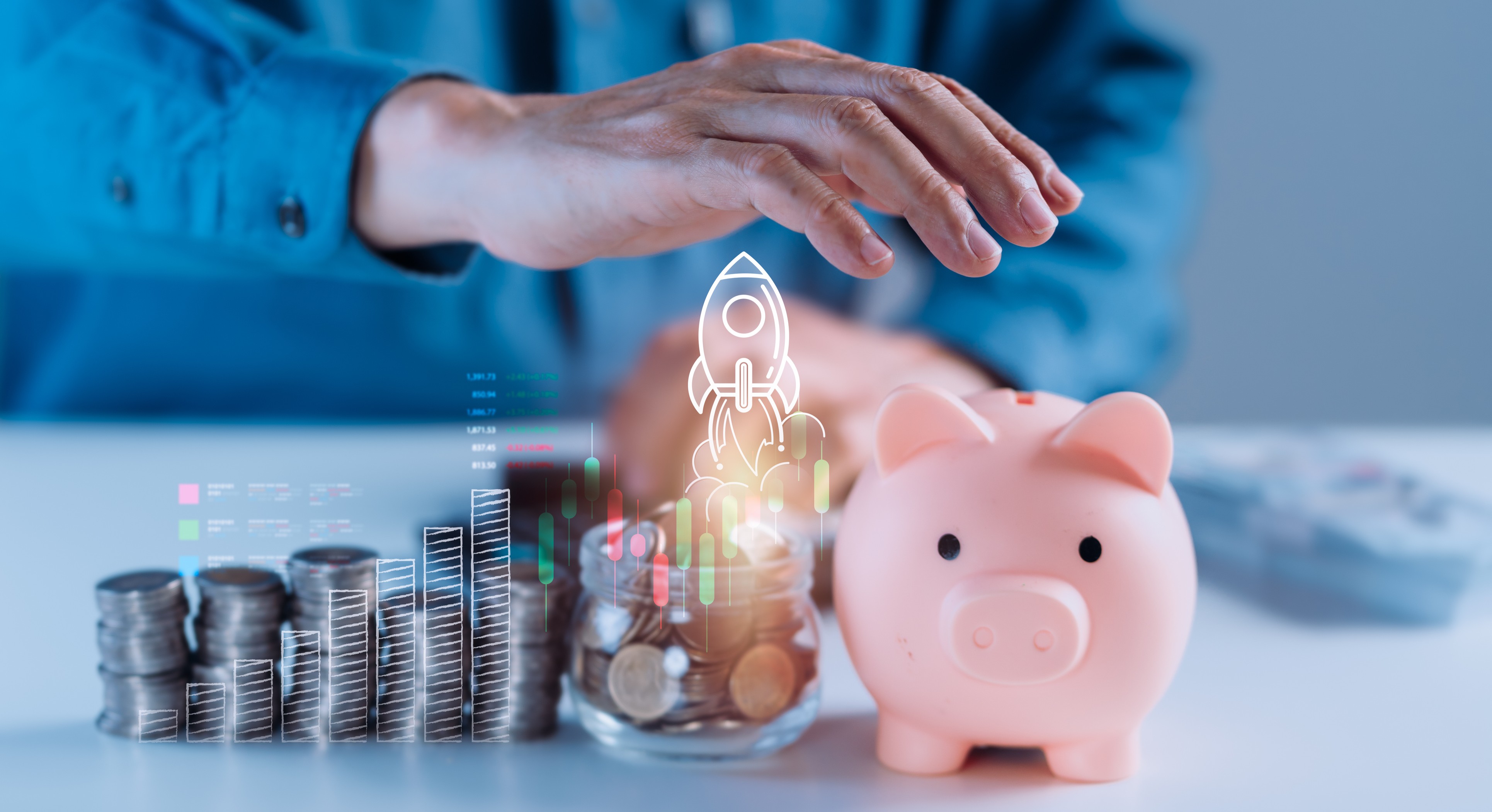 A man protects a pink piggy bank filled with coins, whi