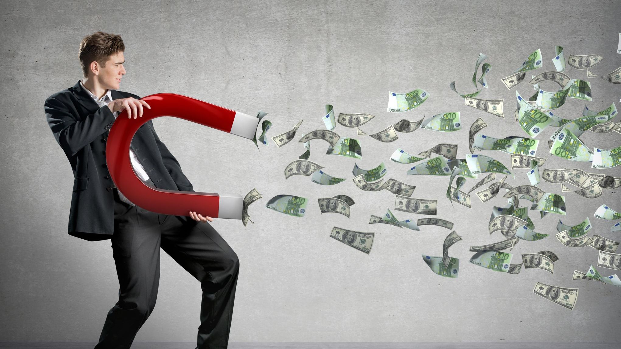 Businessman attracts money with a large magnet